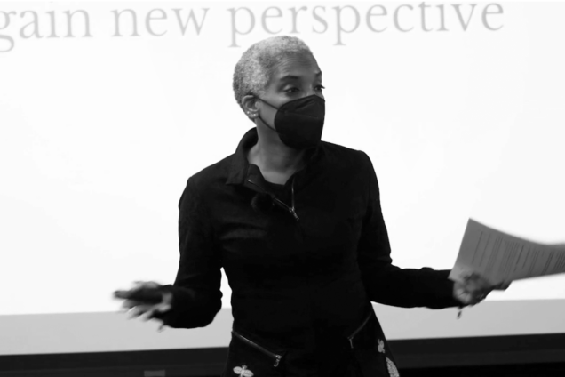 Karen Proctor lecturing while gesturing with arms out