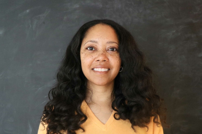 Lona Vincent with dark wavy hair and a yellow top.