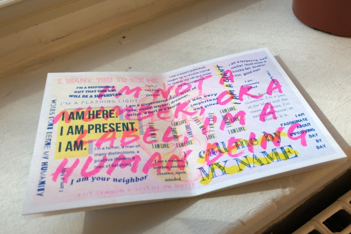 An image of a pamphlet with lots of colorful writing on it. Written over all of the text in pink marker reads: