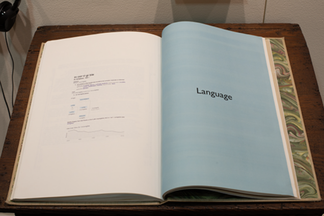 An open book on a wooden pedestal. The right page is entirely light blue with black text in the center of it that reads: 
