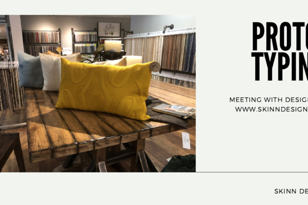 A picture of yellow, white, and blue pillows arranged on a wooden table. Surrounding the table are cutouts of thick fabric.