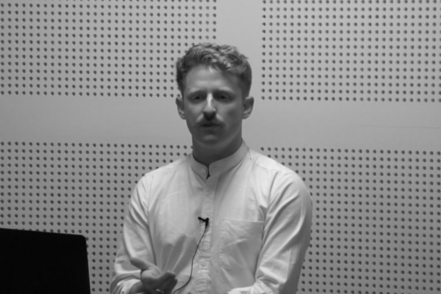 A man wearing a white button down shirt giving a presentation.