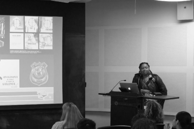 A black woman standing at a podium giving a presentation.