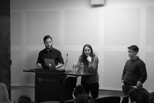 Three people standing at a podium giving a group presentation.