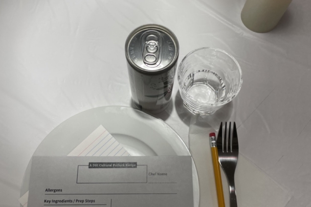 A place setting on a table with a recipe card on a white plate.