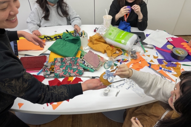 Mari and students in a sewing activity.
