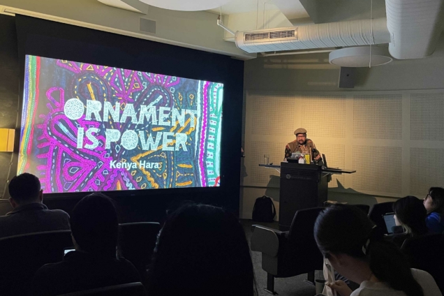 Ishan Khosla presenting in a dark MFA DSI auditorium. On the screen it says 