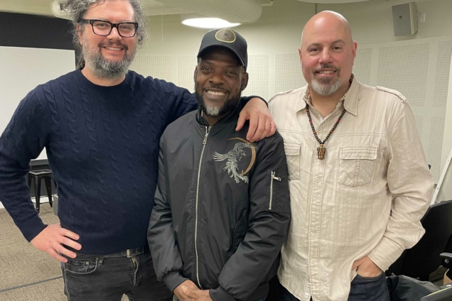 Director AJ Wilhelm stands with Jerome Simeon AKA Junior Racine Mapou, and drummer Markus Schwartz in the MFA DSI Auditorium.