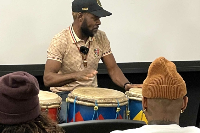 Jerome Simeon AKA Junior Racine Mapou plays Haitian drums in the MFA DSI Auditorium.