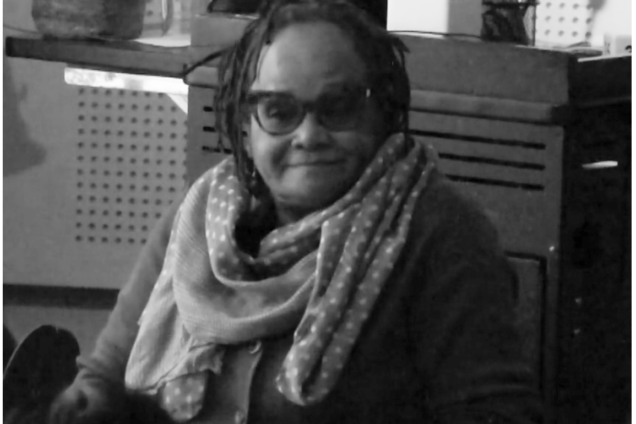 Woman with glasses sitting and presenting.