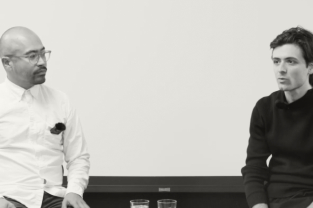 2 guys presenting. One is wearing a white shirt & the other a black sweater