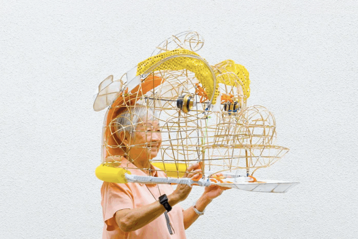 Elderly woman with wooden lion's head on.