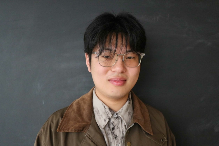 DSI student with glasses and a brown jacket.