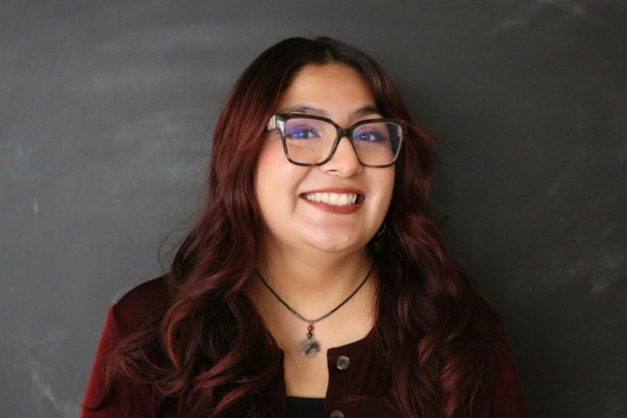 DSI student with dark red wavy hair and glasses in a burgundy top.