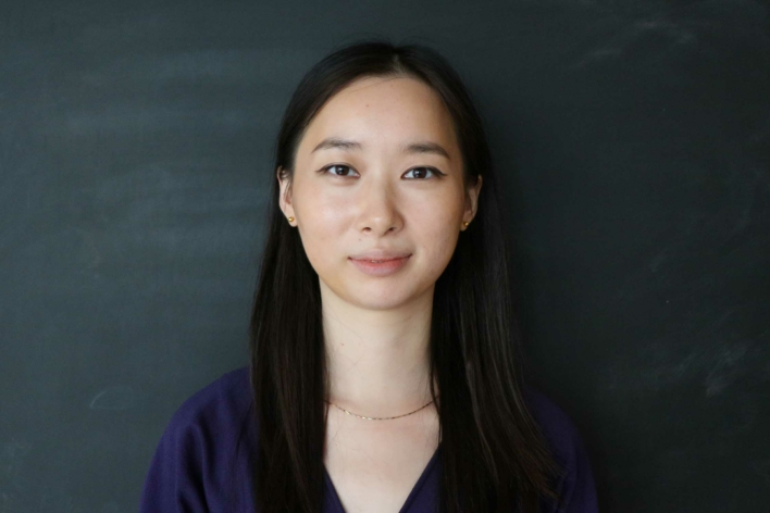 DSI student with long black hair and a v-neck dark blue top.