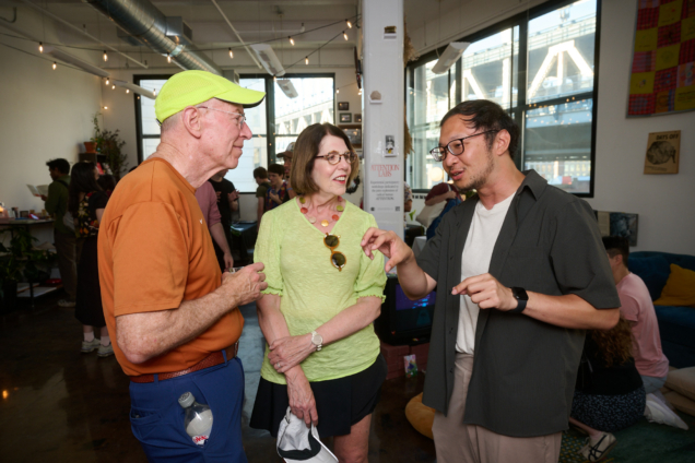 Hao Jie Sim speaking to two attendees at the SoRA opening.