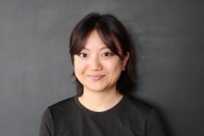 MFA DSI Graduate student with black hair wearing a black tshirt against a grey background
